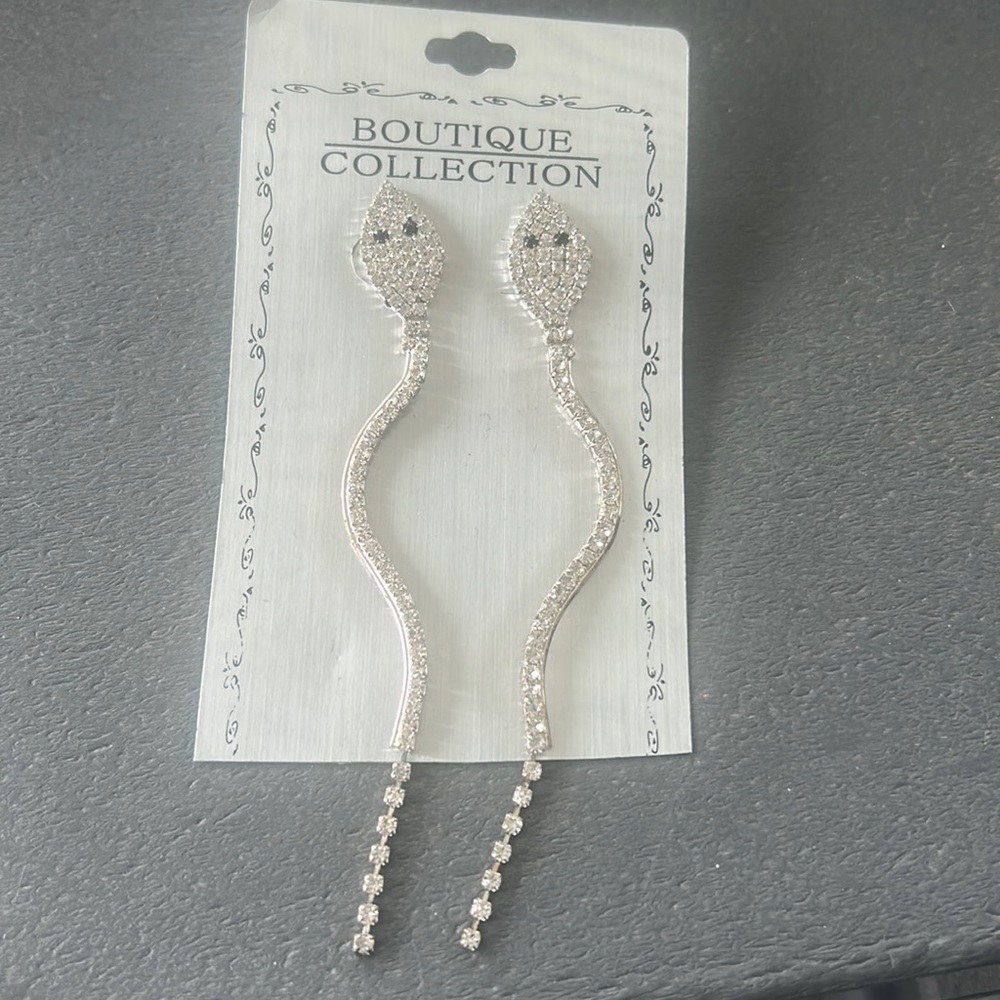 Brand new! Never worn. Snake dangle earrings. Clear rhinestones, black eyes